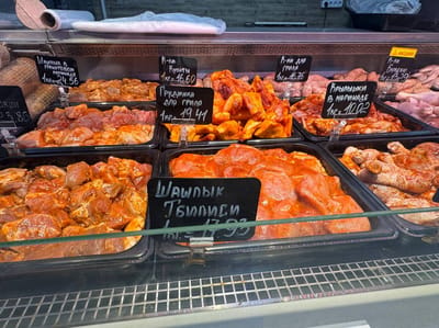 Витрина с маринованным мясом и шашлыком в магазине Слонима с ценниками на продукцию