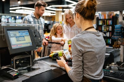 продавец на кассе обслуживает покупателей