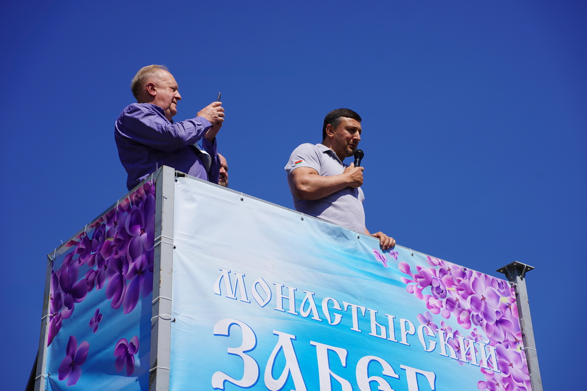 Иван Тихон с микрофоном обращается к участникам «Монастырского забега» со стартовой площадки под открытым небом.