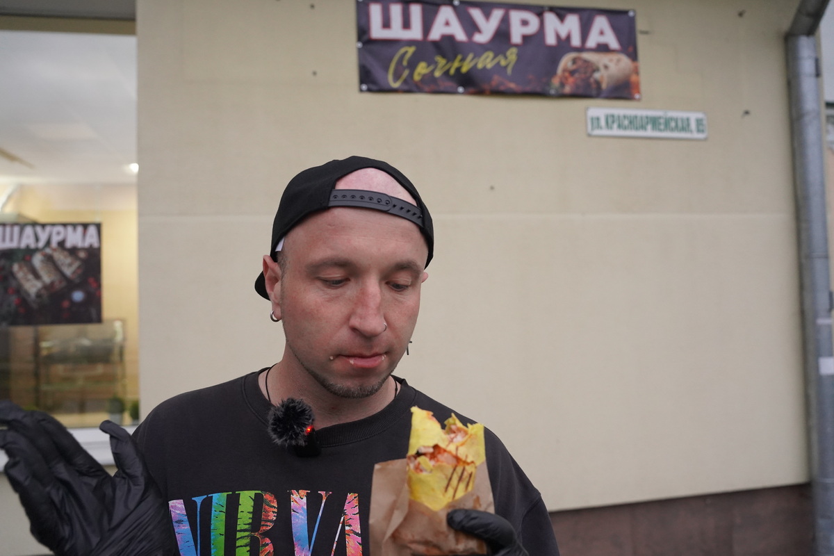 Никита держит надкушенную шаурму на фоне вывески «Шаурма Сочная»