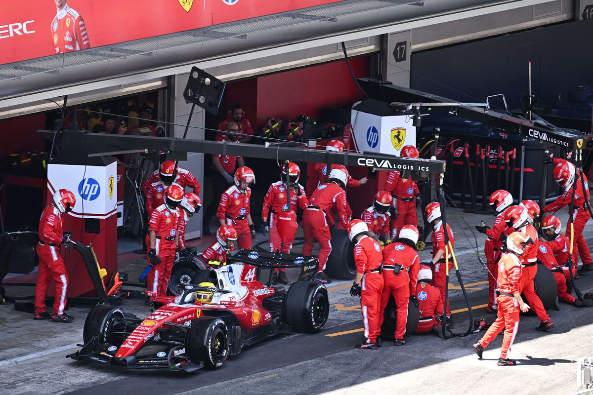 Болид Льюиса Хэмилтона на пит-стопе, механики Ferrari меняют шины